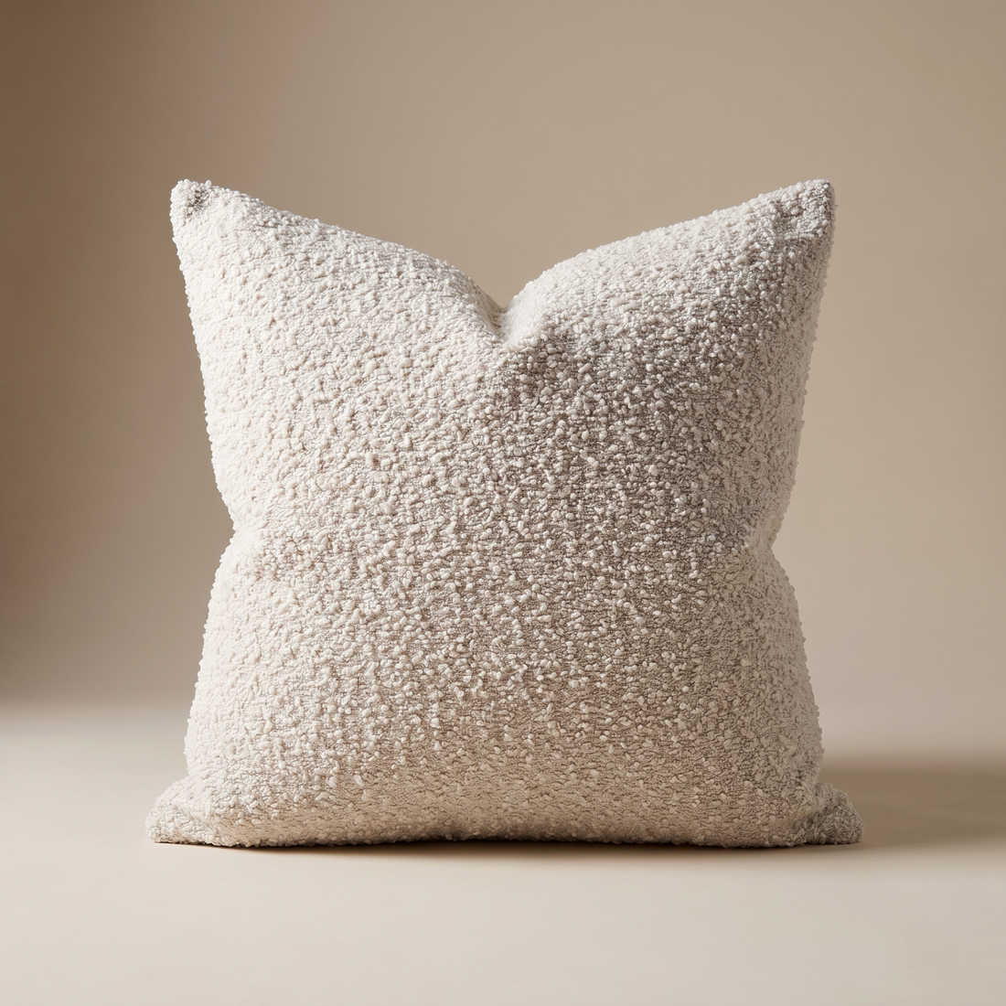 Bouclé cushion cover properly filled with a correctly oversized insert for a plump, rounded silhouette