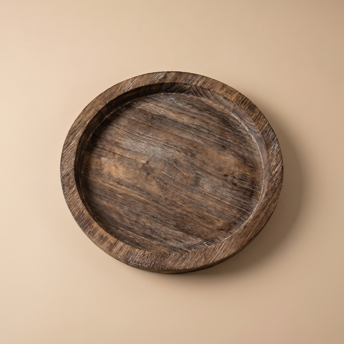Round wood decorative tray styled as a multi-purpose catchall on a table