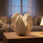 Cream ceramic bloom vase on a sideboard in a warm, cozy living room at dusk