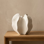 Cream ceramic sculptural bloom vase styled on a warm oak console table