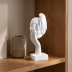 Abstract face statue paired with a vase on a warm-toned shelf