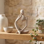 Abstract Thinker resin figurine on a neutral open shelf