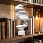 White abstract mask-profile resin sculpture on a bookcase shelf