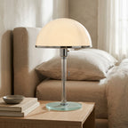 Bauhaus dome table lamp casting a warm ambient glow in a living room setting