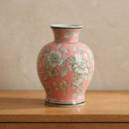 Pink floral chinoiserie ceramic vase styled on a warm oak console table