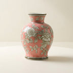 Coral-pink chinoiserie ceramic vase with white peony floral pattern, on a warm-white studio backdrop