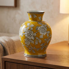 Yellow floral chinoiserie ceramic vase styled on a sideboard in a warm living room