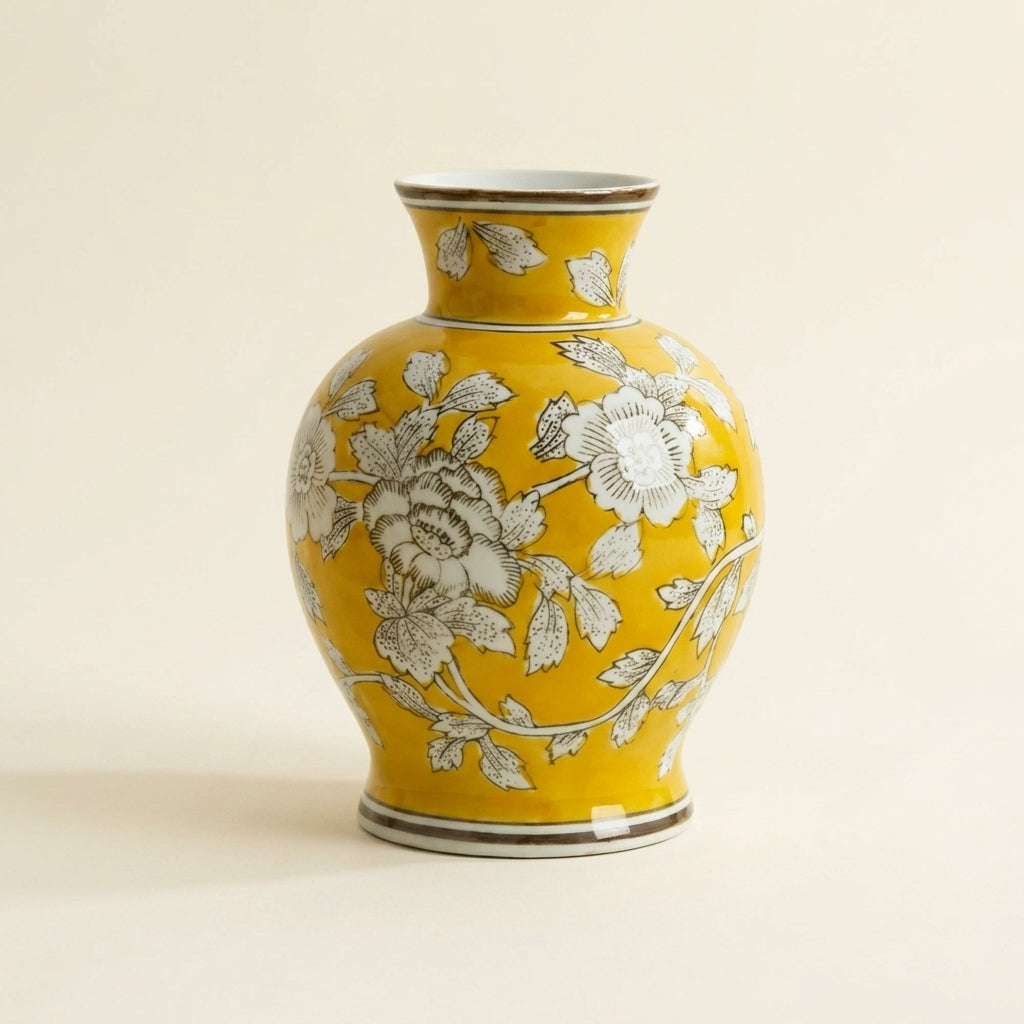 Mustard-yellow chinoiserie ceramic vase with white peony floral pattern, on a warm-white studio backdrop
