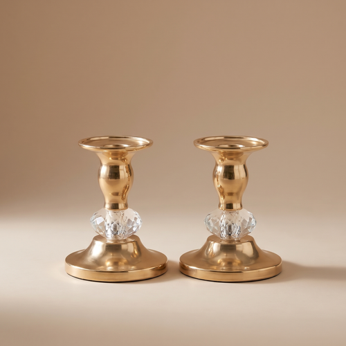 Pair of brass taper candle holders on a linen-dressed dining table