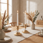 Brass candlestick set arranged on a neutral table runner with dried stems