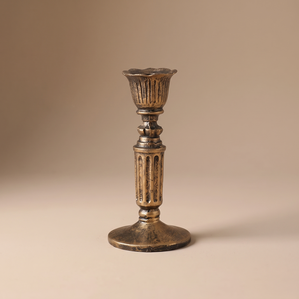 Antique bronze taper candle holder on a linen-draped dining table