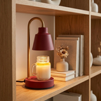 Deep red candle warmer lamp warming a candle on a shelf
