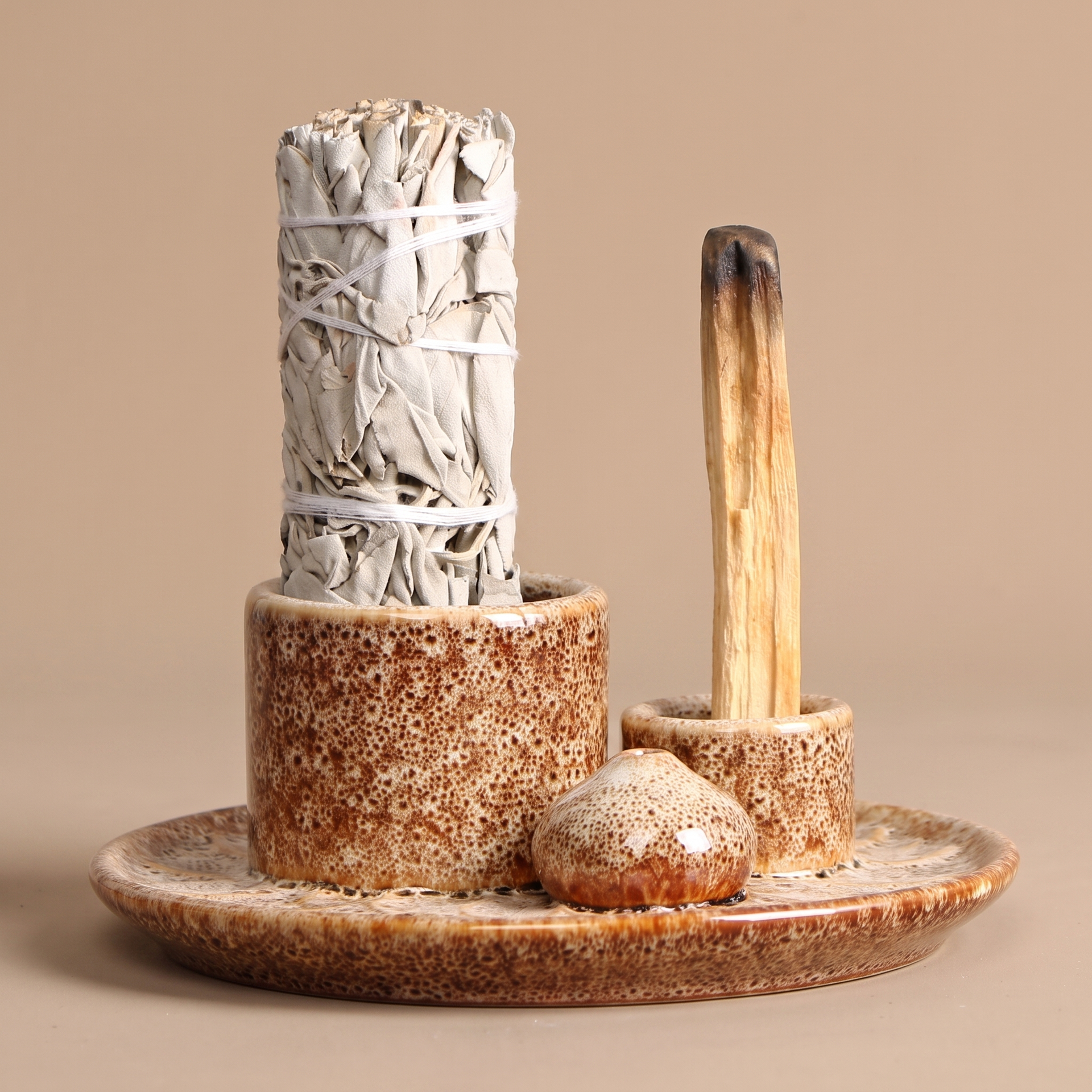 Speckled ceramic 4-in-1 incense burner on a linen-draped meditation shelf