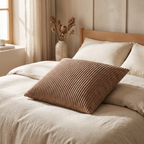 Two corduroy cushion covers stacked on a wooden bench