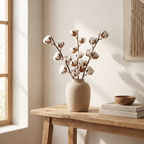 Cluster of cream faux cotton stems styled on a wooden console table