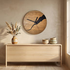 Warm wood cracked-split wall clock with black hands above a light-wood sideboard in a minimalist dining nook