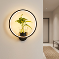 Black round ring wall lamp with plant vase as a warm accent in a hallway