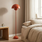 Glossy red-orange mushroom-dome floor lamp with a slim straight pole and rounded base