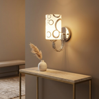 Chrome patterned-glass wall sconce above a console table in an entryway