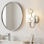 Chrome patterned-glass wall sconce beside a round mirror on a vanity wall