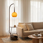 Arched floor lamp beside a reading chair with warm amber glow