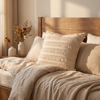 Ivory fringed-edge square cushion cover on a bed