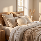 Cream round fringed cushion cover styled on a bed