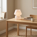 Glass mushroom lamp glowing on a light-wood home office desk