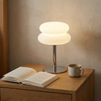 USB cream-style table lamp casting a warm glow beside the bed