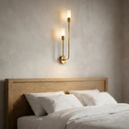Nordic luxe black-and-gold wall sconce — above oak headboard with linen bedding