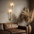 Nordic luxe black-and-gold wall sconce — above leather sofa as living-room accent
