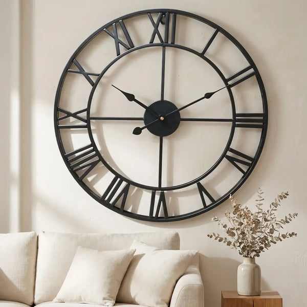 3D Roman numeral metal wall clock — on plaster gallery wall above linen sofa