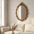Gold oval vintage hanging wall mirror — on plaster gallery wall above linen sofa