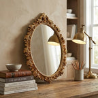 Gold oval vintage hanging wall mirror — in calm home office above wooden desk