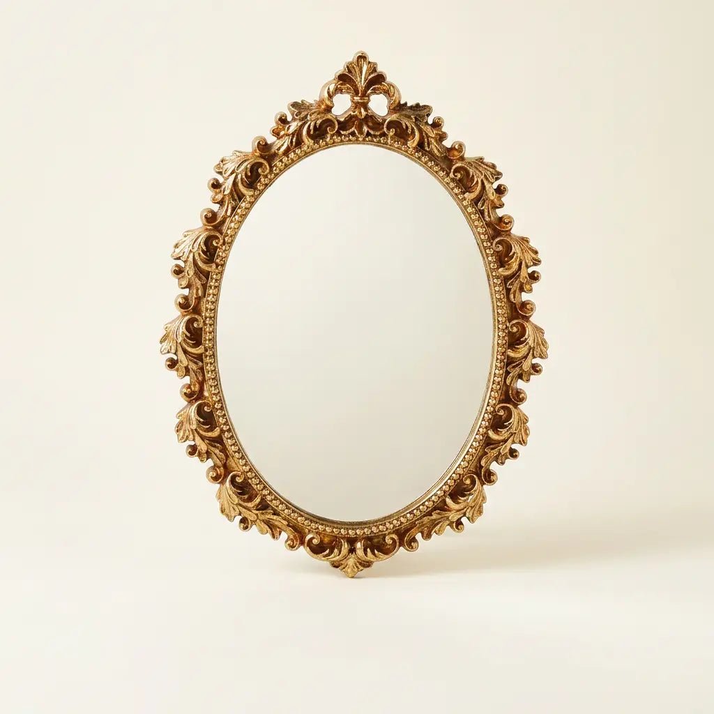 Gold oval vintage hanging wall mirror — on warm cream studio backdrop