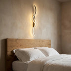 Long strip LED wall sconce — above oak headboard with linen bedding