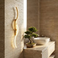Long strip LED wall sconce — above travertine bathroom vanity