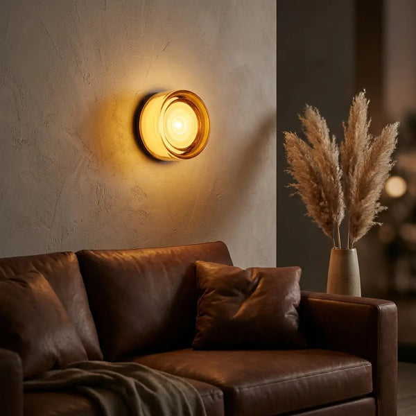 Round opal glass wall sconce — above leather sofa as living-room accent