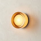 Round opal glass wall sconce — on textured plaster wall product shot