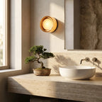 Round opal glass wall sconce — above travertine bathroom vanity