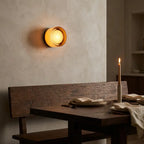 Round opal glass wall sconce — above dining bench in warm ambience