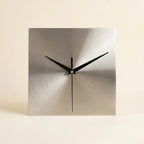 Stainless steel wall clock — on warm cream studio backdrop
