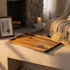Natural acacia wood rectangular tray — on plaster fireplace mantel