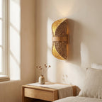 Woven rattan-look fiber wall sconce casting a soft, warm glow around its edges on the wall at night.