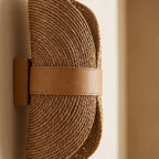 Close-up of the coiled rope-like weave on the curled half-moon sconce shade.