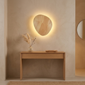 Oval wood wall light above a console table in an entryway