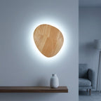 Oval natural wood-grain wall light shown with the cool White light option, crisp cool-white backlit halo