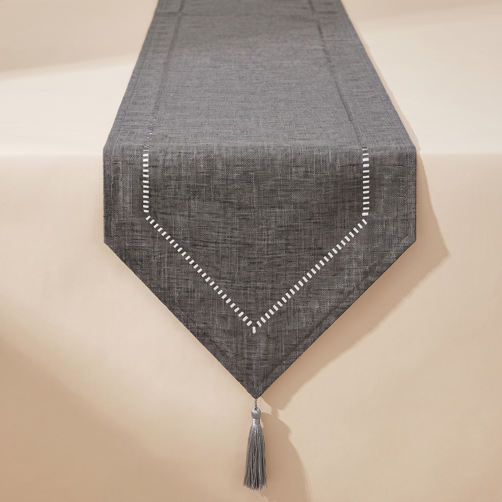 Linen-look table runner in gray draped down a wooden dining table