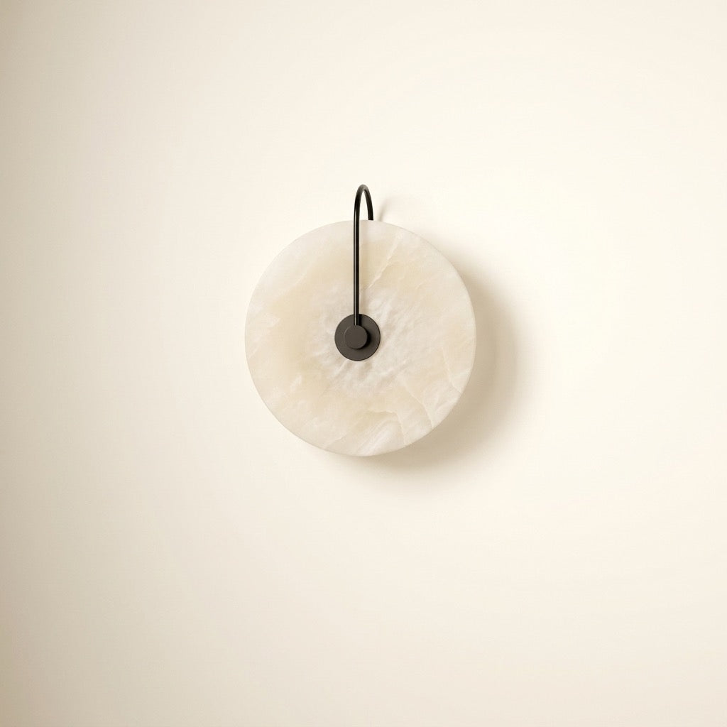 Alabaster-look moon disc wall sconce with a glowing translucent disc and curved black arm