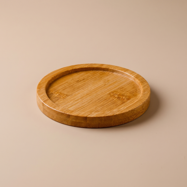Round natural bamboo mini tray holding a ceramic coffee cup on a wood table